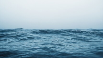 A minimalist image of ocean waves rolling softly toward the shore, with a wide-open horizon in the distance