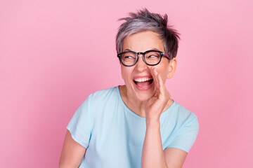 Wall Mural - Photo of nice aged woman communicate empty space blue t-shirt isolated on pink color background