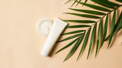 Wall Mural - Mock-up. A tube of cream sitting next to a palm leaf, beige background