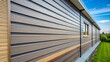 © kansak01 - Horizontal rows of modular plastic panels create a durable exterior siding by overlapping seams, providing a