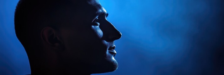 Wall Mural - A profile silhouette of a person against a blue smoky background.