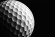 © SRENStock - A white golf ball on a tee against a black background