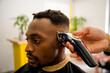 © ADDICTIVE STOCK - Black man getting a stylish haircut at a coast barber shop