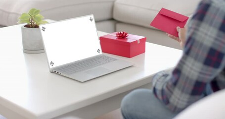 Poster - Caucasian man holding envelope and using laptop with copy space on blank screen