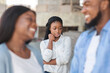 © Prostock-studio - Third wheel. Upset black girl jealous to her dating friends, standing alone on background outdoors, selective focus