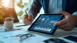 © Studios - The businessman analyzing tablet data