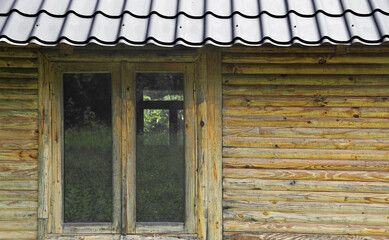 brown yellow window frame with wooden frame. front view of a wood home varnished wall exterior as background.