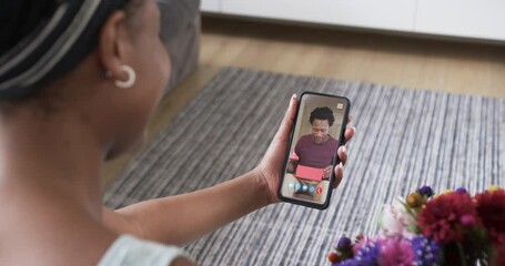 Canvas Print - African american woman holding smartphone with african emerican man with gift on screen