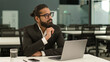 © Yuliia - Arabian man Indian office worker at workplace table ethnic business employer entrepreneur guy male businessman typing laptop browsing working with computer think pensive finish online work thinking