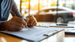 © Xingguo - Driver signing an auto insurance policy with sleek car in the background, documents neatly spread on the desk, symbolizing vehicle protection, legal responsibility, and financial security.