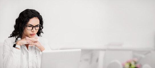 Poster - Concentration Concept. Focused mexican businesswoman working on laptop at office. Copy space