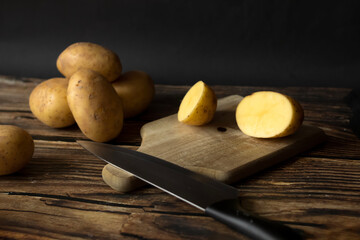 young raw potato. on a dark wooden background. food