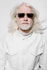 Wall Mural - White haired man with sunglasses, stylish fashion concept against a plain white background, exuding confidence and modernity, ideal for lifestyle and fashion content