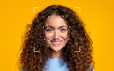 a woman with curly hair smiles brightly as a facial recognition overlay appears on her face against 