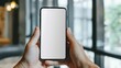 © DYNECREATIVE - Close-up hands holding smartphone with blank screen for mockups, office indoor setting, clean design for business and technology themes.