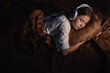© Andrii Lysenko - Teen girl peacefully sleeping on a pillow with headphones on, creating a serene and relaxed atmosphere