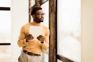 Poster - Modern Technologies. Focused black businessman holding digital tablet, standing by window, copyspace