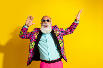 portrait of overjoyed aged man star shape sunglass enjoy dancing isolated on yellow color background
