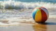 © วรรณภา มะโนศรี - A close-up of a colorful beach ball on the sand with gentle waves in the background, capturing the fun and vibrancy of a summer day.
