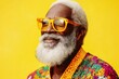 © W. Thienthongthai - Elderly man with a white beard wearing a colorful outfit and yellow-tinted glasses against a yellow background.