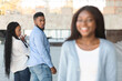 © Prostock-studio - Infidelity concept. Unfaithful black womanizer guy turning around amazed at another woman while walking with his girlfriend on street