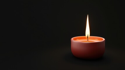 A candle is lit in a red bowl on a black background