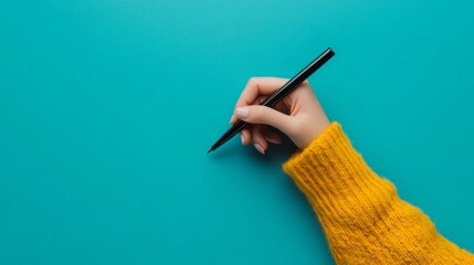 Wall Mural - Girl's Hand Writing with Black Pen on Pastel Blue Background