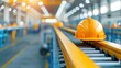 © Vilaysack - Safety helmet placed on a conveyor belt in a large industrial factory, symbolizing workplace safety and manufacturing.