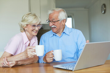 Wall Mural - woman laptop man computer retirement senior adult couple home coffee tea cup drink table female wife
