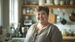 © kora studio - middle age american chubby housewife and mom is smiling in her kitchen