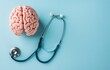 © Georgii - Top view of a brain model with stethoscope on blue background, symbolizing healthcare and medical research