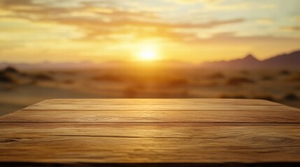 A wooden table in the foreground with a sunset over a desert landscape in the background.