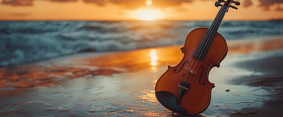 Wall Mural - A violin on a sandy beach at sunset, with the ocean waves in the background.