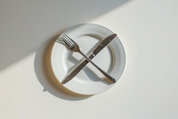 Poster - A simple white plate with a fork and knife placed on it, suitable for use in various settings