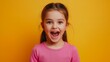 © BROPRADANA - Portrait of a happy little girl with her mouth wide open on a yellow background.