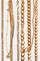 Aufkleber - A collection of gold chains arranged neatly on a white background