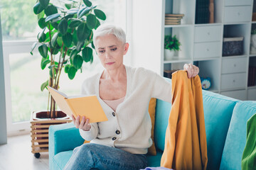 Poster - Photo of charming lovely senior woman dressed white cardigan hold planner dirty jumper read home cleaning tasks indoors