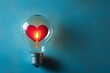 © kenkuza - Red heart in light bulb on blue background with copy space