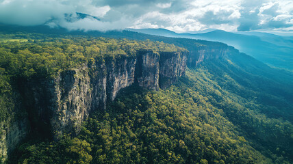 Wall Mural - Aerial view of mountain range covered in lush green vegetation, showcasing stunning cliffs and valleys