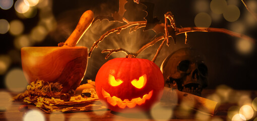 Wall Mural - Halloween composition with jack-o-lantern, mortar, pestle and tree branches on wooden table