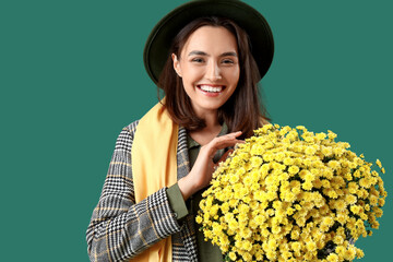 Poster - Young woman with chrysanthemum flowers on green background