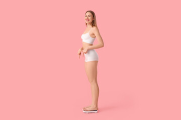 Poster - Young woman measuring weight on pink background. Diet concept