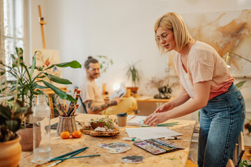 Wall Mural - Creative female artist choosing painting tool at creative art studio.