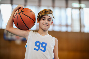 Wall Mural - Young basketball player posing with ball