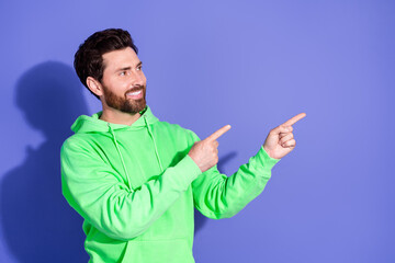 Wall Mural - Photo portrait of brunet hair mature age funky man wearing neon green hoodie pointing fingers empty space promo cafe isolated on violet color background