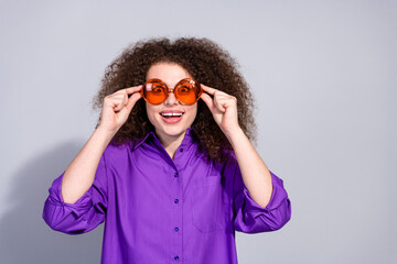 Wall Mural - Portrait of pretty young woman touch sunglass empty space wear violet shirt isolated on grey color background