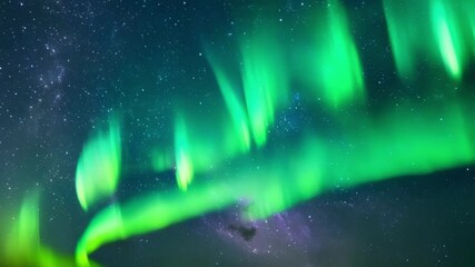 Aufkleber - The night sky is illuminated by the vibrant green hues of the aurora borealis, creating a breathtaking natural spectacle above a distant mountain range