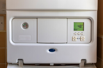 Cost of Living Crisis Concept: Open gas boiler control panel to turn down boiler temperature