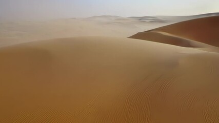 Poster - Sand blowing over sahara desert dunes creates beautiful patterns in golden hues, adding adventure to remote, wild terrain. Ideal for travelers seeking unique scenic experiences