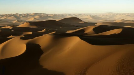 Poster - Sunlight casting long shadows on the sand dunes, creating a mesmerizing pattern of light and shadow in a vast and desolate landscape